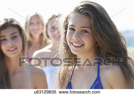 Stock Photography - Portrait of girl with sisters in background. Fotosearch
