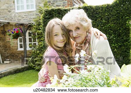 Portrait of grandmother and granddaughter with arms around each other View Large Photo Image Picture - Portrait of grandmother and granddaughter with arms around each other. Fotosearch