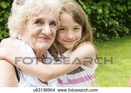 Portrait of grandmother and granddaughter hugging View Large Photo Image Picture - Portrait of grandmother and granddaughter hugging. Fotosearch
