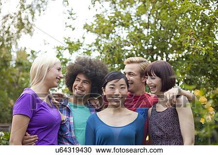 Portrait of group of friends hugging in garden View Large Photo Image Stock Image - Portrait of group of friends hugging in garden. Fotosearch