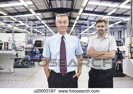 Portrait of manager and co-worker in engineering factory View Large Photo Image Stock Photo - Portrait of manager and co-worker in engineering factory. Fotosearch