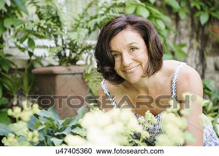 Portrait of mature woman in garden View Large Photo Image Stock Image - Portrait of mature woman in garden. Fotosearch