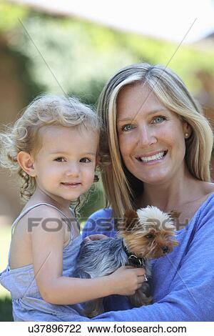 Portrait of mother holding young daughter and dog View Large Photo Image Stock Image - Portrait of mother holding young daughter and dog. Fotosearch