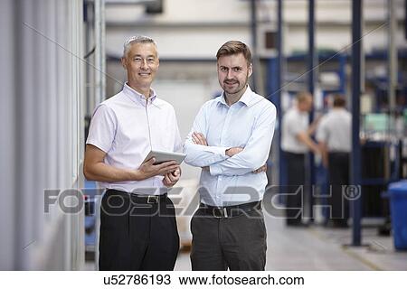 Stock Image - Portrait of two engineers in engineering factory. Fotosearch