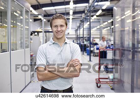 Stock Photo - Portrait of worker with arms folded in engineering factory. Fotosearch