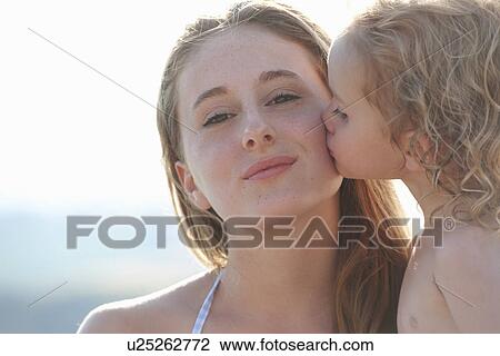 Portrait of young girl kissing older sister View Large Photo Image Stock Image - Portrait of young girl kissing older sister. Fotosearch