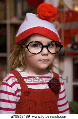 Stock Photo - Portrait of young girl wearing fake glasses and bobble hat. Fotosearch