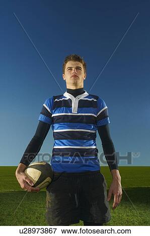 Portrait of young man holding rugby ball View Large Photo Image Stock Photo - Portrait of young man holding rugby ball. Fotosearch