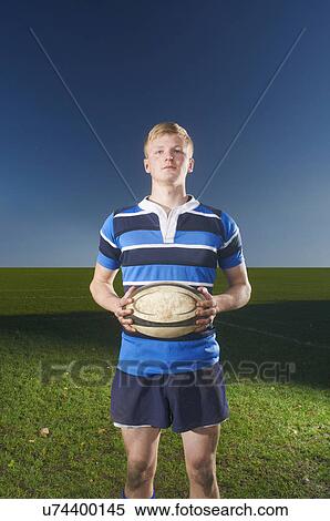 Portrait of young man holding rugby ball View Large Photo Image Stock Photography - Portrait of young man holding rugby ball. Fotosearch