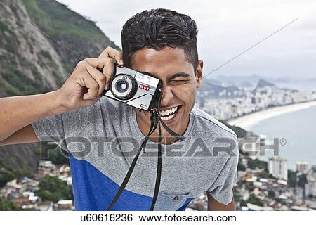 Portrait of young man with camera, Casa Alto Vidigal, Rio De Janeiro, Brazil View Large Photo Image Stock Photograph - Portrait of young man with camera, Casa Alto Vidigal, Rio De Janeiro, Brazil. Fotosearch
