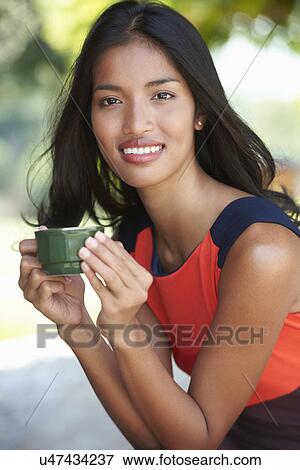 Portrait of young woman holding coffee cup View Large Photo Image Stock Photo - Portrait of young woman holding coffee cup. Fotosearch