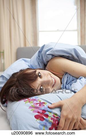 Portrait of young woman in bed View Large Photo Image Stock Photograph - Portrait of young woman in bed. Fotosearch