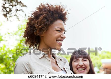 Portrait of young woman laughing with afro hairstyle View Large Photo Image Stock Image - Portrait of young woman laughing with afro hairstyle. Fotosearch