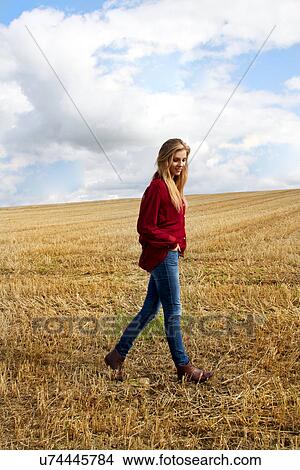 Portrait of young woman walking in harvested field View Large Photo Image Picture - Portrait of young woman walking in harvested field. Fotosearch
