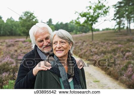 Stock Image - Senior couple, man with hands on woman's shoulders. Fotosearch