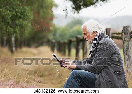 Senior man using digital tablet View Large Photo Image Stock Photograph - Senior man using digital tablet. Fotosearch