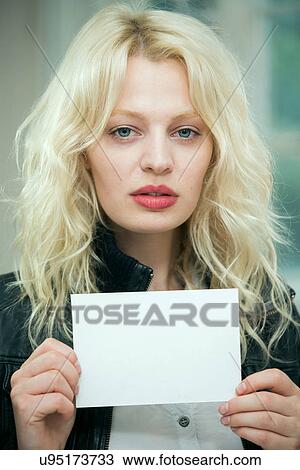 Stock Image - Serious young woman holding a blank card. Fotosearch