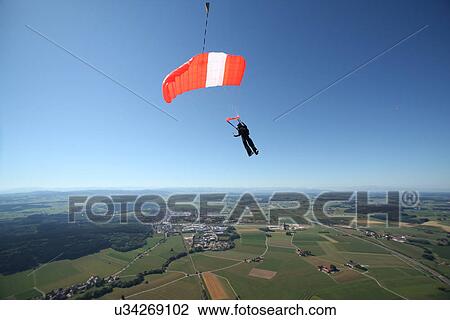 Skydiver parachuting down above Leutkirch, Bavaria, Germany View Large Photo Image Stock Image - Skydiver parachuting down above Leutkirch, Bavaria, Germany. Fotosearch