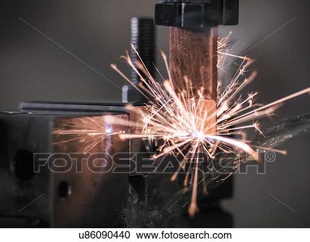 Stock Image - Spark from wire erosion machine in factory. Fotosearch
