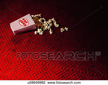 Stock Image - Spilled carton of popcorn on cinema carpet. Fotosearch