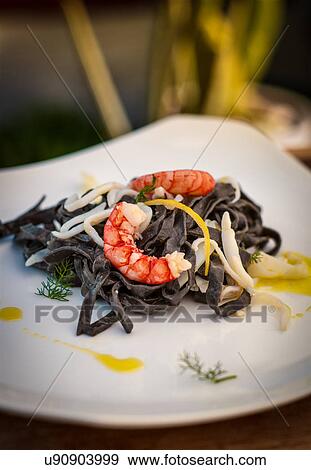 Stock Photo - Still life with black tagliatelle and prawns. Fotosearch
