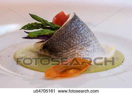 Stock Image - Still life with fish stuffed with asparagus and tomato. Fotosearch