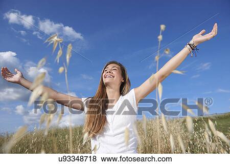 Stock Photo - Teenage girl in field with arms out, Tuscany, Italy. Fotosearch