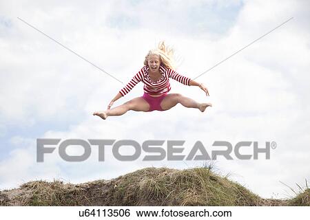 Teenage girl leaping mid air with legs out, Wales, UK View Large Photo Image Stock Photograph - Teenage girl leaping mid air with legs out, Wales, UK. Fotosearch