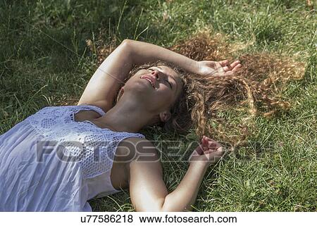 Teenage girl lying on grass, Prague, Czech Republic View Large Photo Image Stock Photo - Teenage girl lying on grass, Prague, Czech Republic. Fotosearch