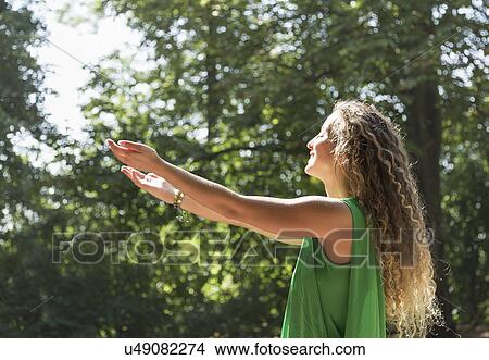 Teenage girl wearing green top with arms out, Prague, Czech Republic View Large Photo Image Picture - Teenage girl wearing green top with arms out, Prague, Czech Republic. Fotosearch