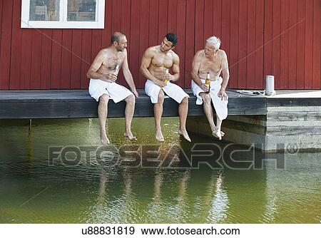 Three male friends sharing a beer outside sauna View Large Photo Image Stock Photo - Three male friends sharing a beer outside sauna. Fotosearch