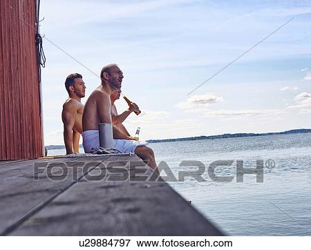 Three male friends sitting outside sauna enjoying beer View Large Photo Image Stock Photo - Three male friends sitting outside sauna enjoying beer. Fotosearch