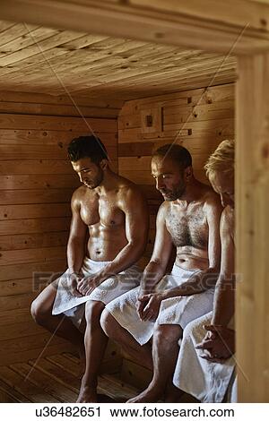 Stock Image - Three men sitting in sauna with heads down. Fotosearch