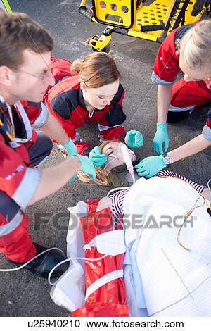 Three paramedics with patient on stretcher wearing oxygen mask View Large Photo Image Stock Image - Three paramedics with patient on stretcher wearing oxygen mask. Fotosearch