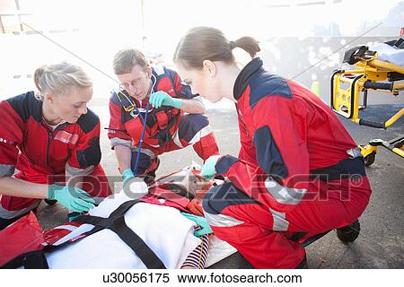 Three paramedics with patient on stretcher wearing oxygen mask View Large Photo Image Stock Photography - Three paramedics with patient on stretcher wearing oxygen mask. Fotosearch