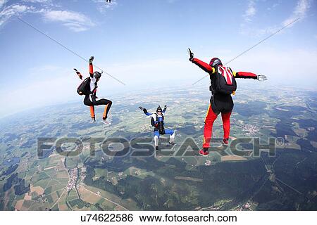 Three skydivers free falling above Leutkirch, Bavaria, Germany View Large Photo Image Stock Photograph - Three skydivers free falling above Leutkirch, Bavaria, Germany. Fotosearch