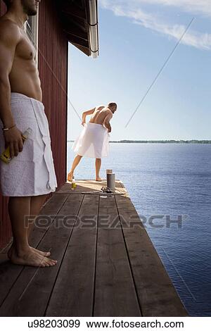 Stock Photo - Two men standing outside sauna. Fotosearch