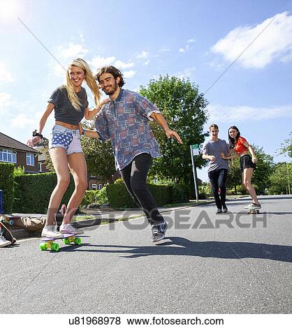 Stock Photo - Two young couples having fun on skateboards. Fotosearch