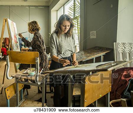 Stock Photo - Two young females painting in artist studio. Fotosearch