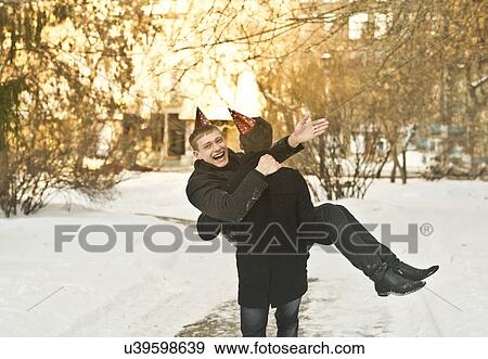 Stock Photo - Two young male friends wearing party hats in park. Fotosearch