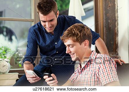 Two young men using smartphones View Large Photo Image Stock Image - Two young men using smartphones. Fotosearch