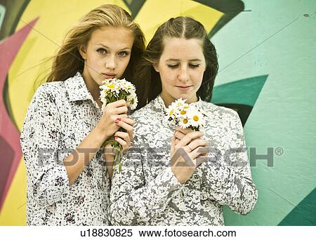 Two young women holding bunches of daisies View Large Photo Image Stock Photography - Two young women holding bunches of daisies. Fotosearch