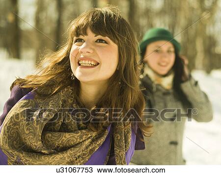 Stock Image - Two young women in snowy park. Fotosearch