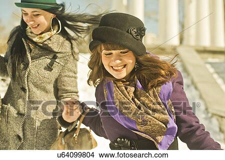 Two young women running in snow View Large Photo Image Picture - Two young women running in snow. Fotosearch