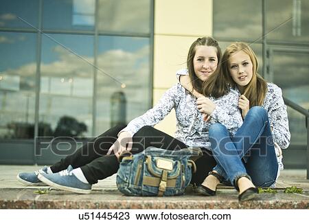 Stock Image - Two young women sitting together. Fotosearch