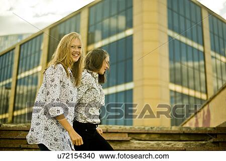 Two young women walking in front of office bulding View Large Photo Image Stock Image - Two young women walking in front of office bulding. Fotosearch