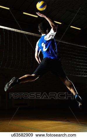 Volleyball player jumping for ball by net View Large Photo Image Stock Photo - Volleyball player jumping for ball by net. Fotosearch