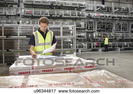 Warehouse worker checking order in engineering warehouse View Large Photo Image Stock Photo - Warehouse worker checking order in engineering warehouse. Fotosearch