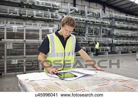 Warehouse worker preparing order in engineering warehouse View Large Photo Image Stock Image - Warehouse worker preparing order in engineering warehouse. Fotosearch