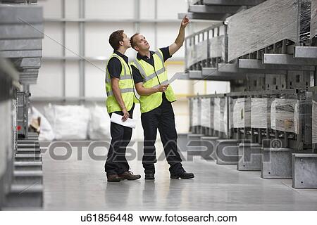 Warehouse workers checking shelves in engineering warehouse View Large Photo Image Stock Photo - Warehouse workers checking shelves in engineering warehouse. Fotosearch